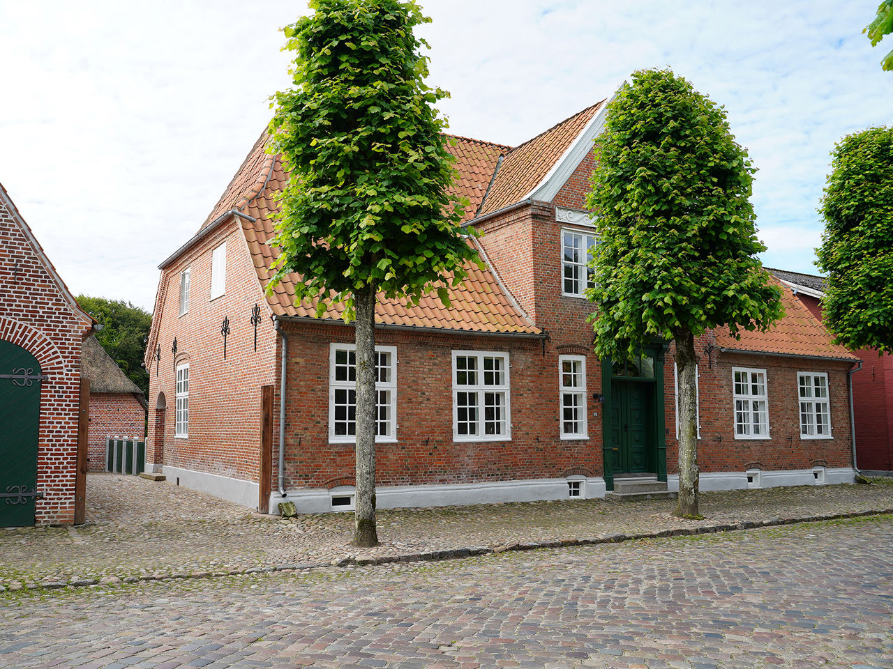 Rødt hus på en gade med brosten